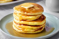 a stack of pancakes with butter on top and syrup drizzled over them