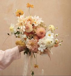 a person holding a bouquet of flowers in their hand