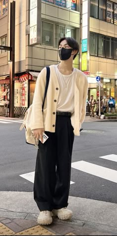 a man wearing a face mask standing on the street