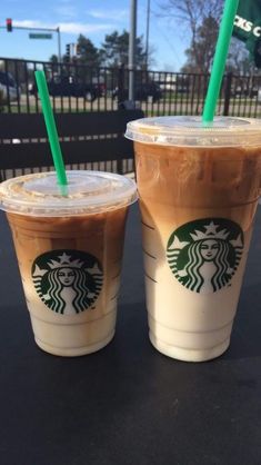 two starbucks drinks sitting next to each other on a table