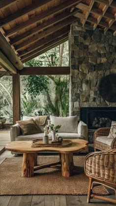 a living room filled with furniture and a fire place next to a stone wall covered in greenery