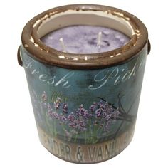 a candle that is sitting inside of a glass container with lavenders on the inside