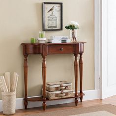 a wooden table sitting next to a wall with a birdcage on top of it