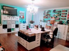 a room filled with lots of white drawers and shelves next to a tv mounted on the wall