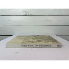 a book sitting on top of a white table next to a wooden paneled wall