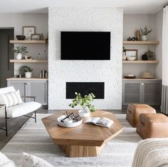 a living room filled with furniture and a flat screen tv mounted on the wall above a fireplace