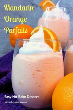 two glasses filled with orange parfaits on top of a purple towel next to an orange