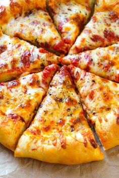 a sliced pizza sitting on top of a wooden cutting board