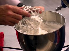 a person mixing something in a metal bowl