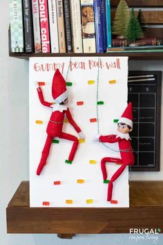 an elf is hanging on the wall next to another elf