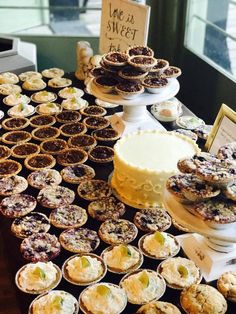 a table topped with lots of pies and cupcakes