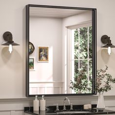 a bathroom sink sitting under a large mirror next to a vase with flowers on it