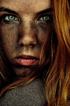 a woman with freckled hair and green eyes