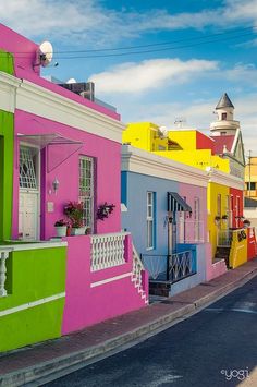 a row of colorful houses on the side of a road