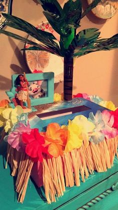 a blue table topped with a potted plant next to a mirror and pictures on the wall