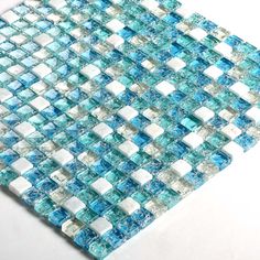 blue and white glass mosaic tile on a white table top, with small squares in the middle