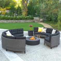 an outdoor living area with couches, tables and fire pit in the middle of it