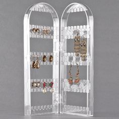 a pair of clear acrylic jewelry stands with earring holders on each shelf