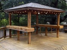 a wooden gazebo sitting on top of a wooden deck next to a park bench