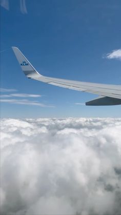 the wing of an airplane flying above clouds