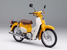 a yellow and white motor scooter with the words super cub 50 on it