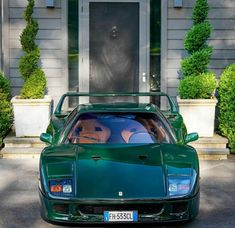 a green sports car parked in front of a house