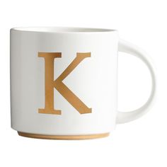 a coffee mug with the letter k in gold foiling on it's side