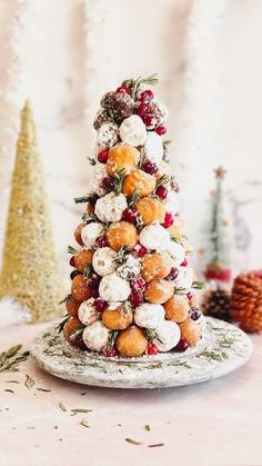 a small christmas tree made out of donuts and cranberries on a plate