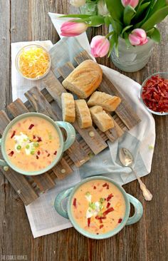 two bowls of soup and bread on a wooden table