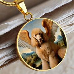 a poodle with wings on it's back is shown in a round pendant