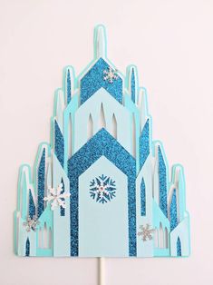 a blue and white paper cutout with snowflakes on it's sides