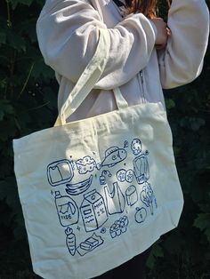 a woman is holding a bag with drawings on it