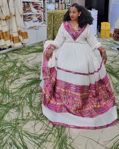 Step into feminine charm with our Pink Design Tilet Habesha Dress, beautifully handwoven using lightweight Menen fabric. The delicate pink design radiates elegance and adds a touch of playfulness to this traditional Ethiopian dress. Meticulously crafted with attention to detail, the intricate threadwork showcases the artistry and skill of Ethiopian weavers. The lightweight cotton material ensures comfort, making it perfect for any occasion. Embrace your unique style with this stunning Habesha dr Traditional Pink Dresses With Traditional Patterns, Pink Maxi Dress For Traditional Ceremonies, Traditional White Handwoven Dress, Pink Dresses For Festivals And Traditional Ceremonies, Pink Dresses For Festivals, Traditional Pink Dress For Festivals, Traditional Pink Maxi Dress, Fitted Pink Dress With Traditional Patterns, Traditional Pink Kaftan For Festivals