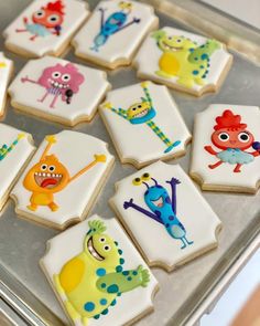 decorated cookies with cartoon characters on them sitting on a cookie sheet in a baking pan