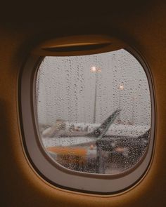 an airplane window with rain drops on it