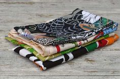 a stack of cloths sitting on top of a wooden table next to each other