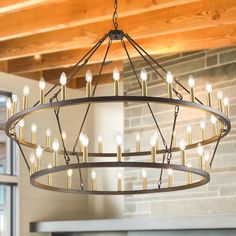 a chandelier hanging from the ceiling in a room with brick walls and beams