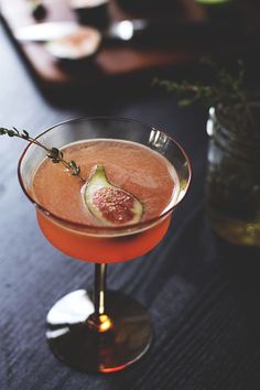 a drink in a glass with a slice of fruit on the rim and garnish