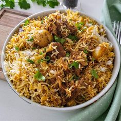 a white bowl filled with rice and meat