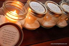 candles are lined up in jars on a table