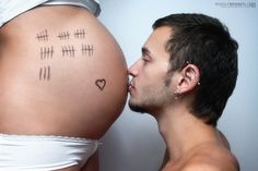 a man kissing his pregnant belly with the words i love you written on its side