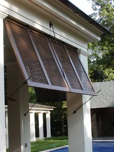 an outside view of a house with a pool in the yard and wooden blinds on the windows