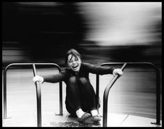 a black and white photo of a woman sitting on the ground with her legs crossed