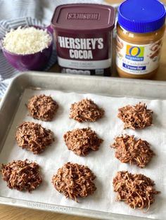 chocolate cookies are on a baking sheet next to peanut butter and other ingredients for the recipe