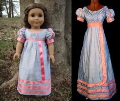 the doll is wearing a blue dress with pink trim