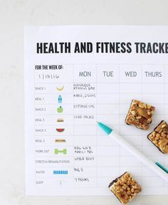 a health and fitness tracker with granola bars on it next to a blue pen