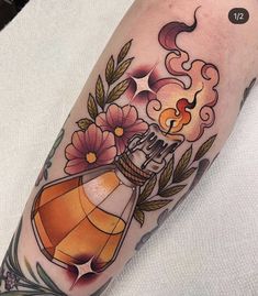 a woman's arm with an orange perfume bottle and flowers on it