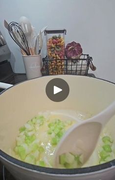 a large pot filled with food on top of a stove next to utensils