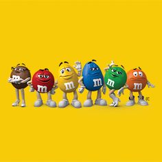 the m & m's characters are lined up in a row on a yellow background