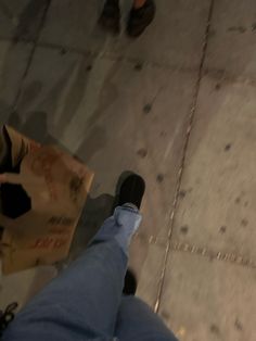 a person standing on the sidewalk with their feet up and holding a bag in his hand